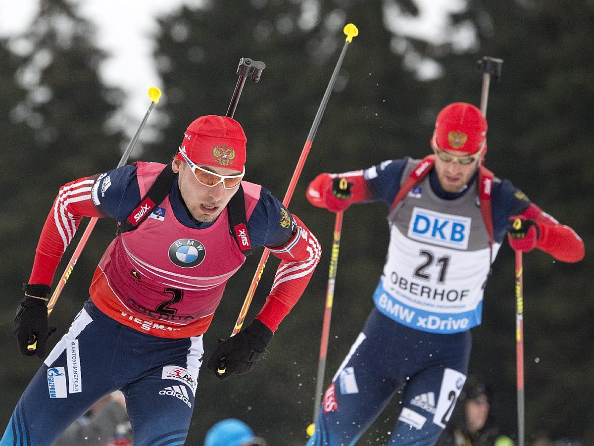 Second placed Anton Shipulin of Russia, left, skis in front of фото (photo)