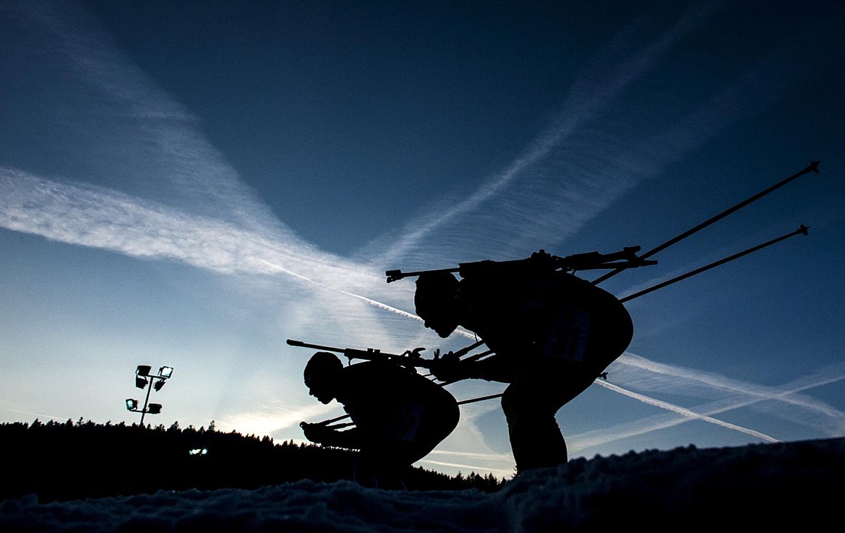Competitors ski during the men's 10 km sprint race at Biathlon фото (photo)