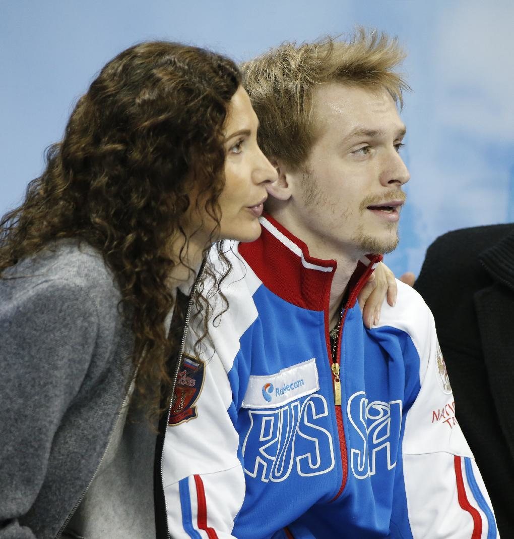 Sergei Voronov of Russia sits with his coach as they wait for фото (photo)