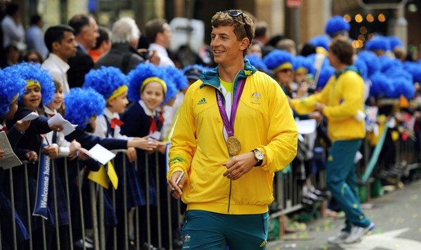 An unidentified Australian Olympian (C) walks past spectators фото