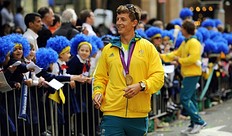 Летние Олимпийские игры An unidentified Australian Olympian (C) walks past spectators фото