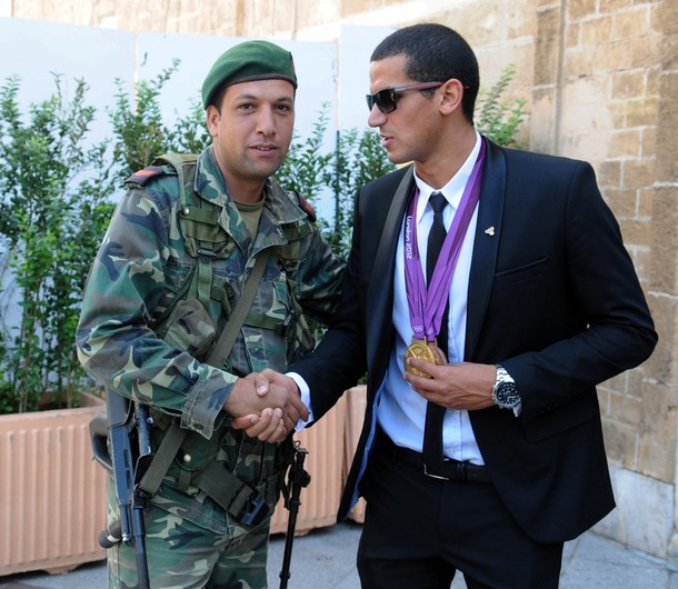 A Tunisian soldier shakes hands with Olympic champion, swimmer фото