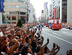 Летние Олимпийские игры Crowds of people wave to Japan's Olympic medallists riding фото