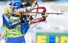 Anna Carin Olofsson-Zidnek, of Sweden, with a photo of her child on her rifle, takes aim while shooting at the rifle range during a training session at the IBU Women's Biathlon World Cup at the Whistler Olympic Park in Whistler, British Columbia, Thursday March 12, 2009.