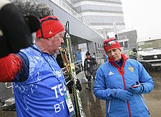 Russia's Olga Zaitseva, right, and her coach Germany's Wolfgang Pichler wait for a shuttle outside the Biathlon stadium at Laura Cross-country Ski & Biathlon...