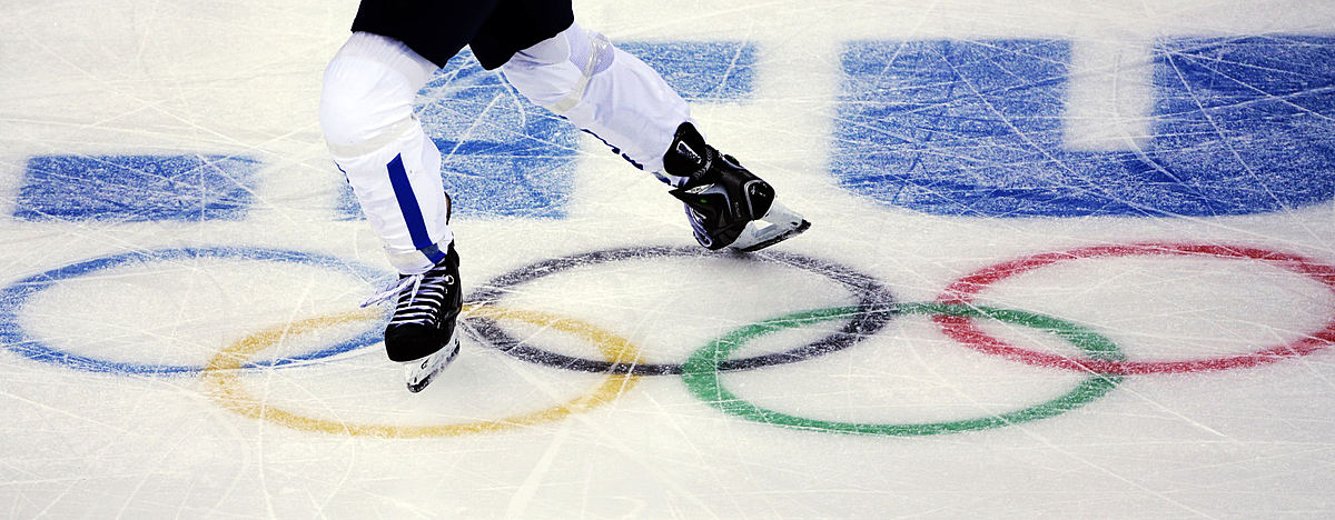 A player skates across the Olympic rings during a first round фото (photo)