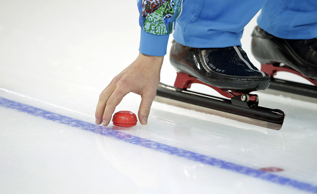 A volunteer puts markers back on the ice after ice machines prepared фото (photo)