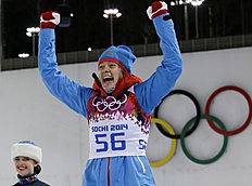 Second placed Russia's Olga Vilukhina jumps on the podium during the flower ceremony after the women's biathlon 7.5k sprint, at the 2014 Winter Olympics,...