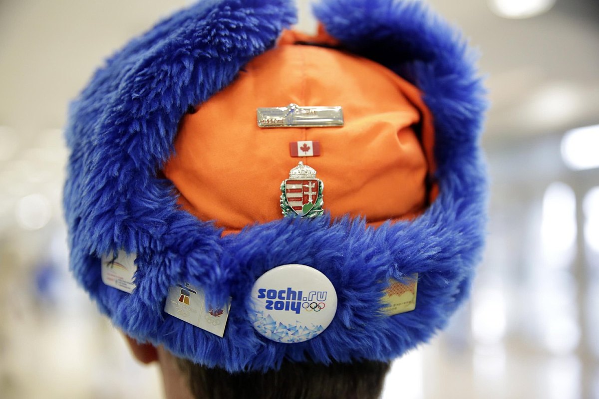 A skating fan sports a cap with Olympic pins on it prior to the фото (photo)