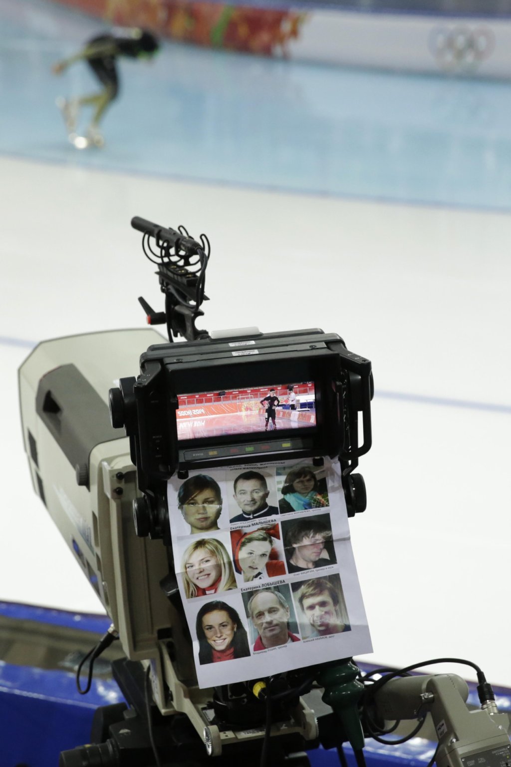A sheet with pictures of athletes is attached to a camera as фото (photo)