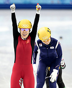 Конькобежный спорт Zhou Yang of China, left, reacts as she crosses the finish line фото (photo)