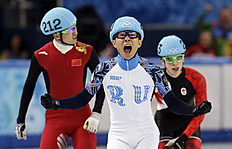 Конькобежный спорт Victor An, center, of Russia, reacts as he crosses the finish фото (photo)