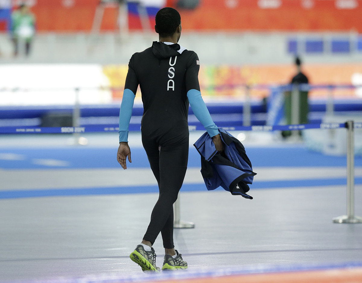 Shani Davis of the U.S. walks holding his jacket after competing фото (photo)