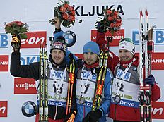 Russia's Anton Shipulin, center, celebrates his victory with second placed Austrian Dominik Landertinger, left and third placed Norwegian Emil Hegle Svendsen...