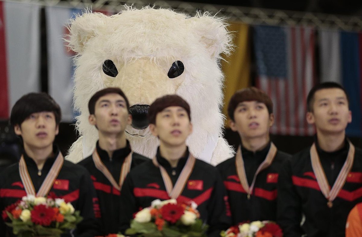 A championship mascot stands behind Chinese team members as they фото (photo)