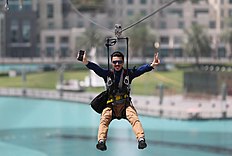 In this April 9, 2016 photo, a man enjoys an urban zip line attraction фото (photo)