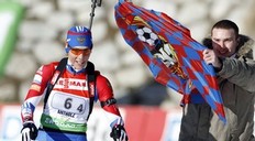 Russia's Olga Zaitseva arrives at the finish area as a fan tries to give a soccer flag of CSKA Moscow during the women's 4x6km relay at the Biathlon World Cup at a ski resort in Anterselva, northeast of Italy January 22, 2011. Russia won the competition ahead of second-placed Sweden and third-placed Germany.