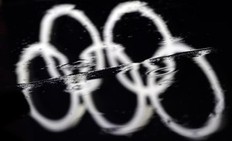 The Olympic rings are reflected in a rain puddle before the medal ceremony for the Women's biathlon 7.5 km of the Vancouver 2010 Winter Olympics at Whistler Medal Plaza venue on February 13, 2010 in Whistler. Bad weather conditions have delayed the start of several events at Whistler Mountain venue but organisers say the conditions are expected to improve from February 15.