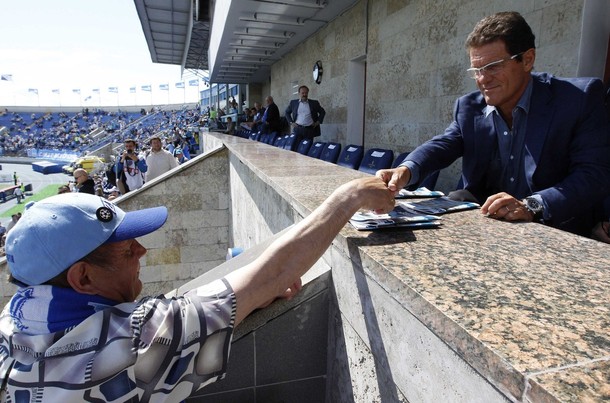 Fabio Capello (R) is greeted by a soccer fan before a Russian фото
