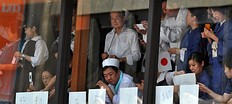 Летние Олимпийские игры Workers and patrols gather near windows to watch Japan' фото