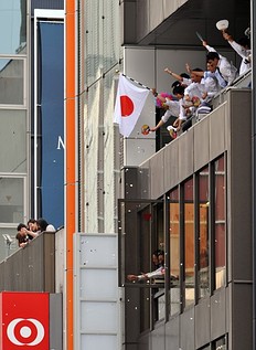 Летние Олимпийские игры Workers wave from their offices as they watch Japan's medallists фото