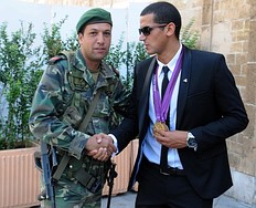 A Tunisian soldier shakes hands with Olympic champion, swimmer фото